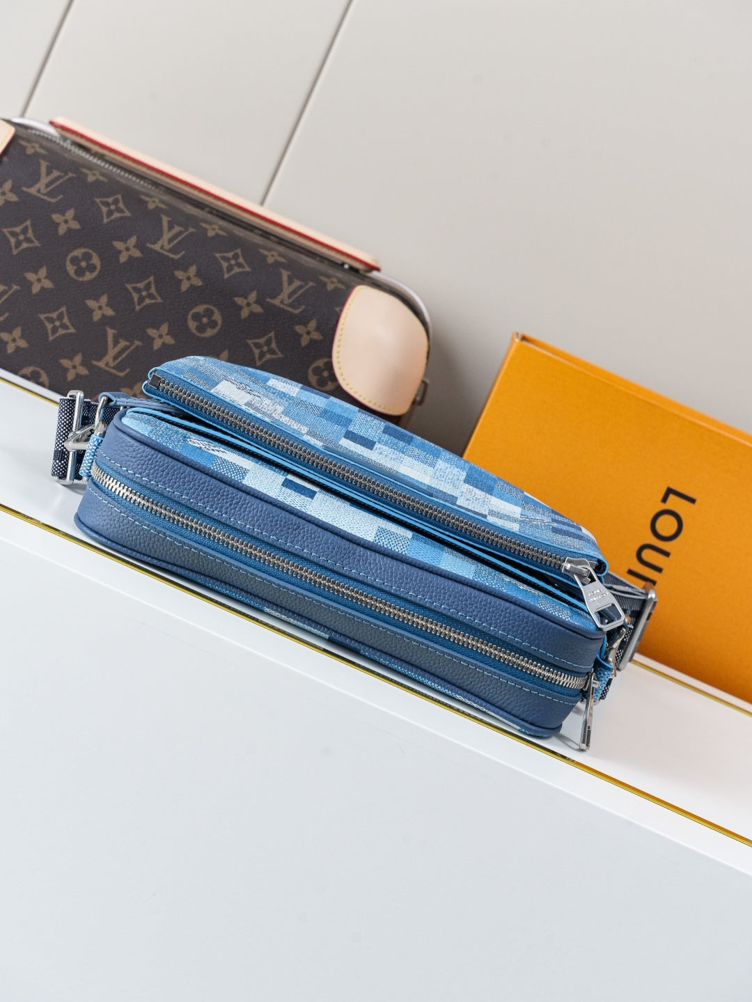Blue checkered crossbody bag with multiple zipper pockets and silver zipper pulls