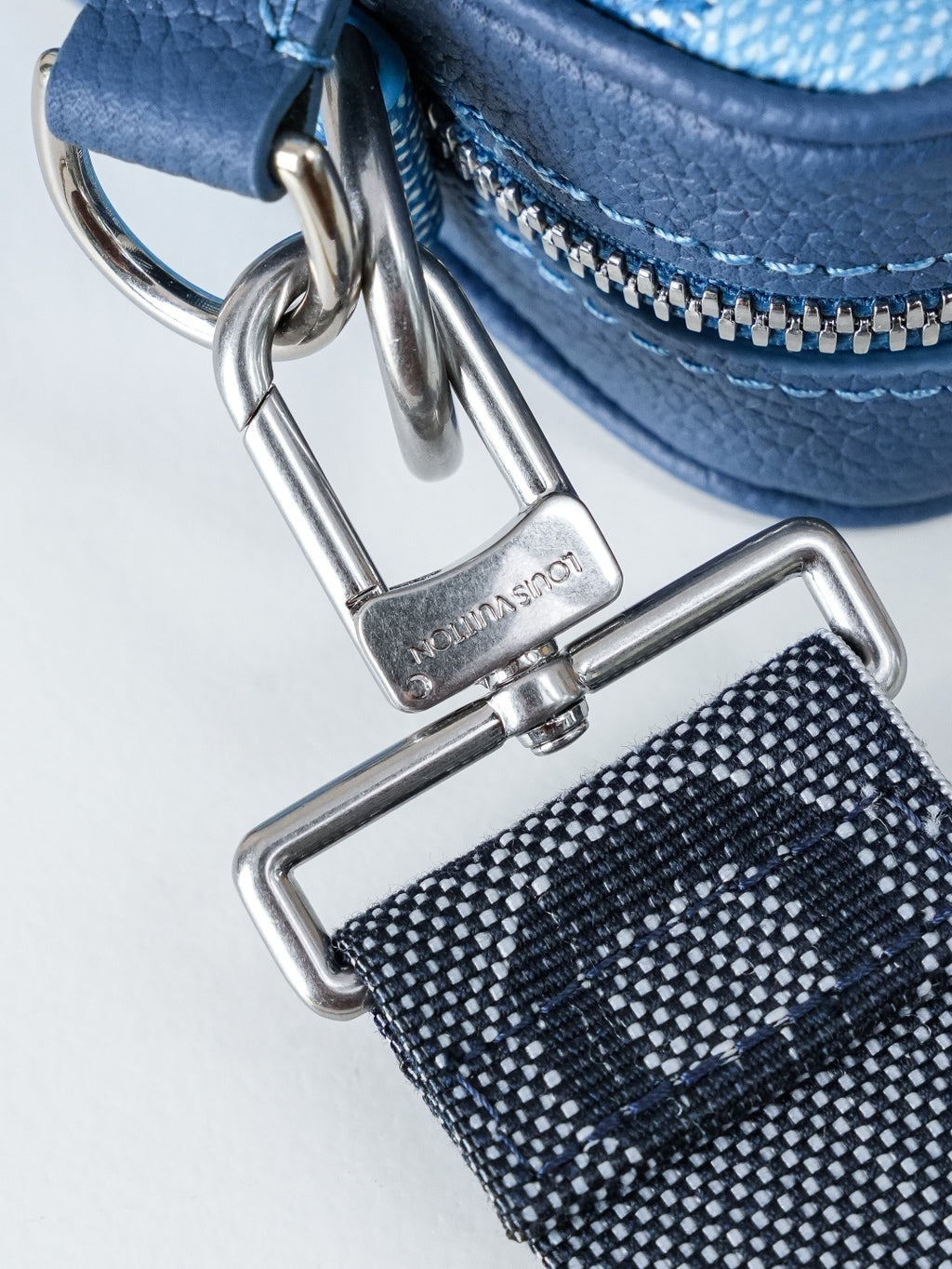 Blue leather bag strap with silver metal clasp and zipper pull