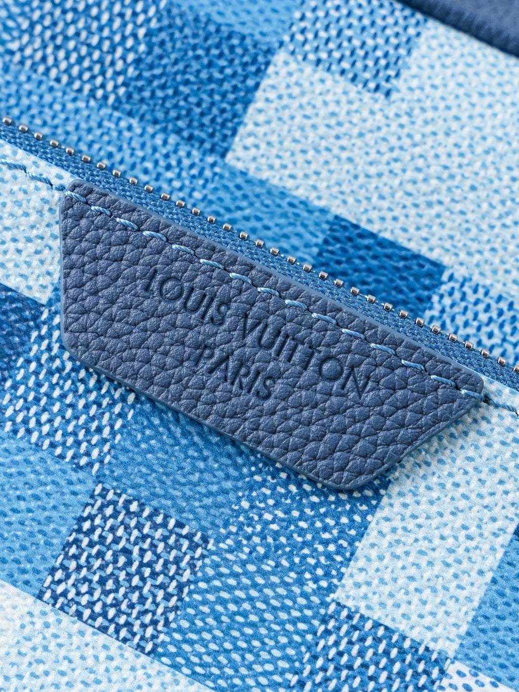 Blue checkered fabric pouch with blue leather logo patch