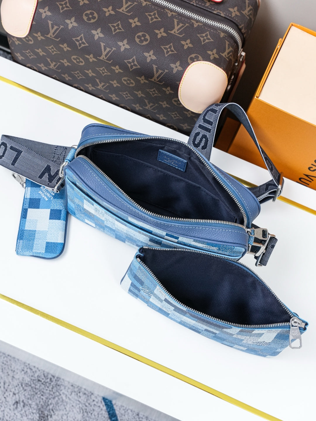Blue checkered crossbody bag open with black lining and zip compartments