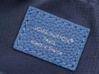 Blue leather brand label on crossbody bag with embossed text