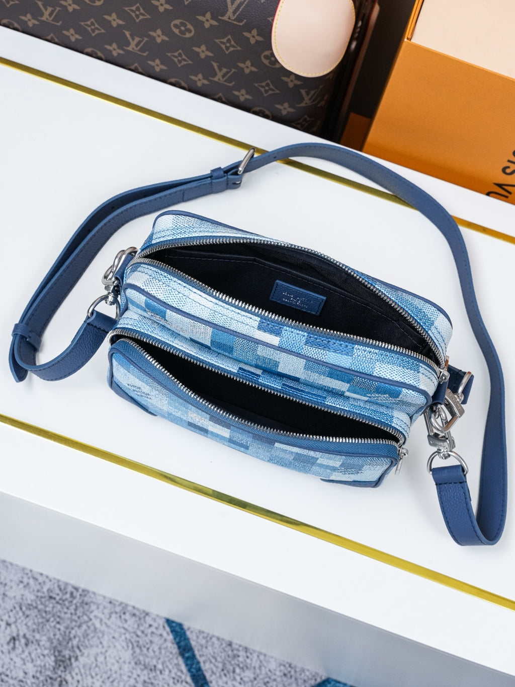 Blue check-pattern crossbody bag with two zip pockets and blue shoulder strap