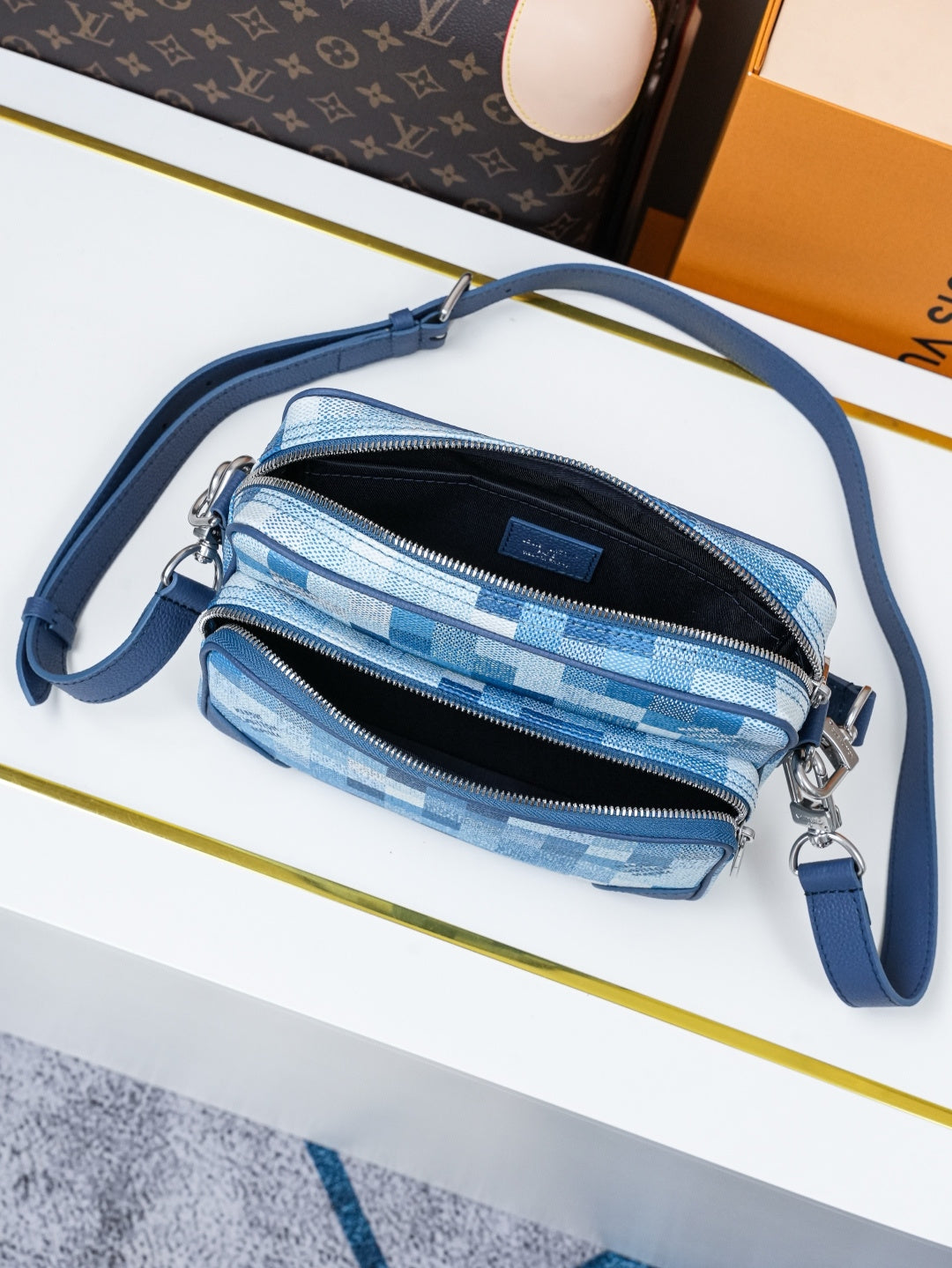 Blue check-pattern crossbody bag with two zip pockets and blue shoulder strap