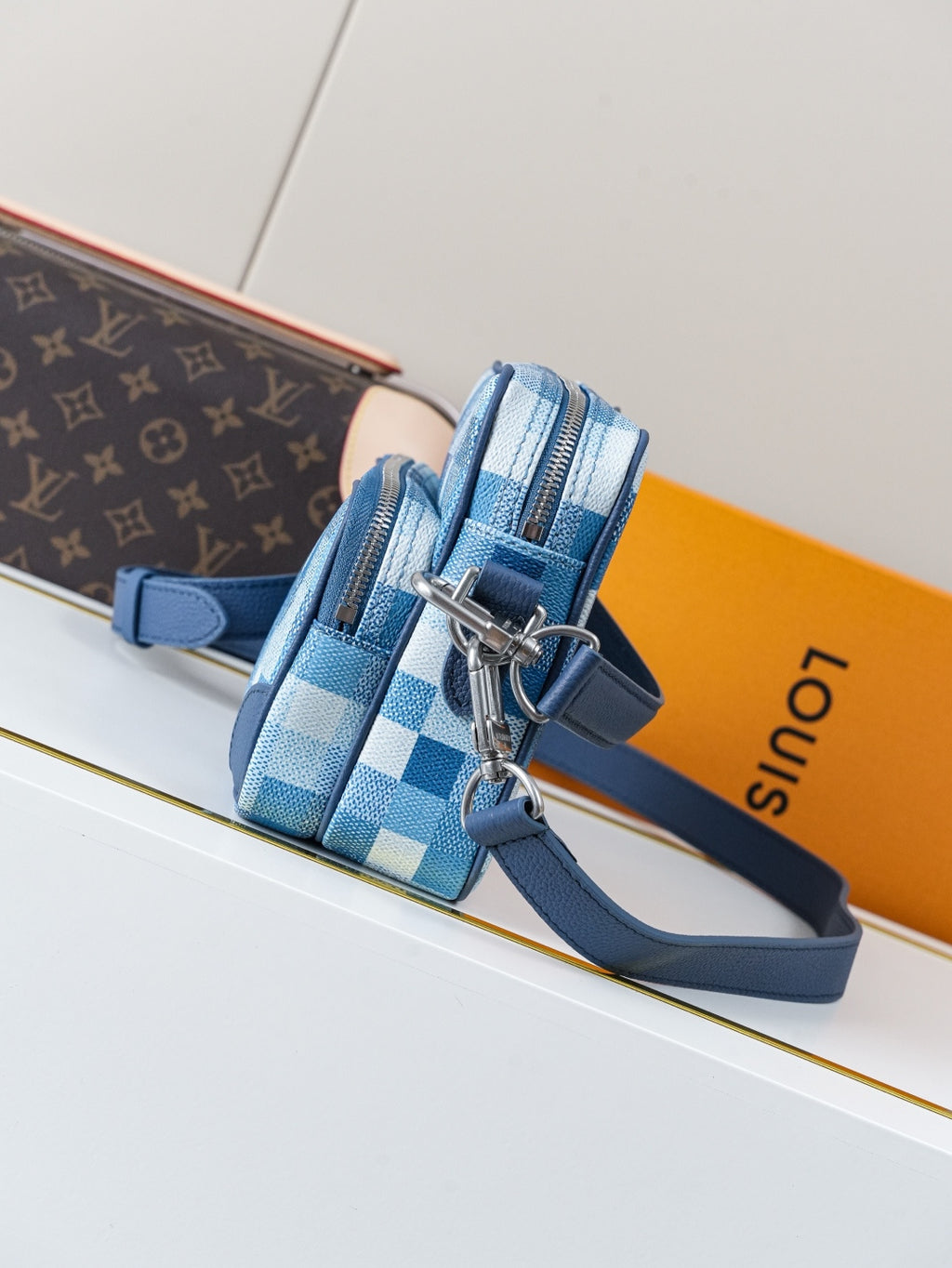 Blue check-pattern mini crossbody bag with side zipper and adjustable blue strap