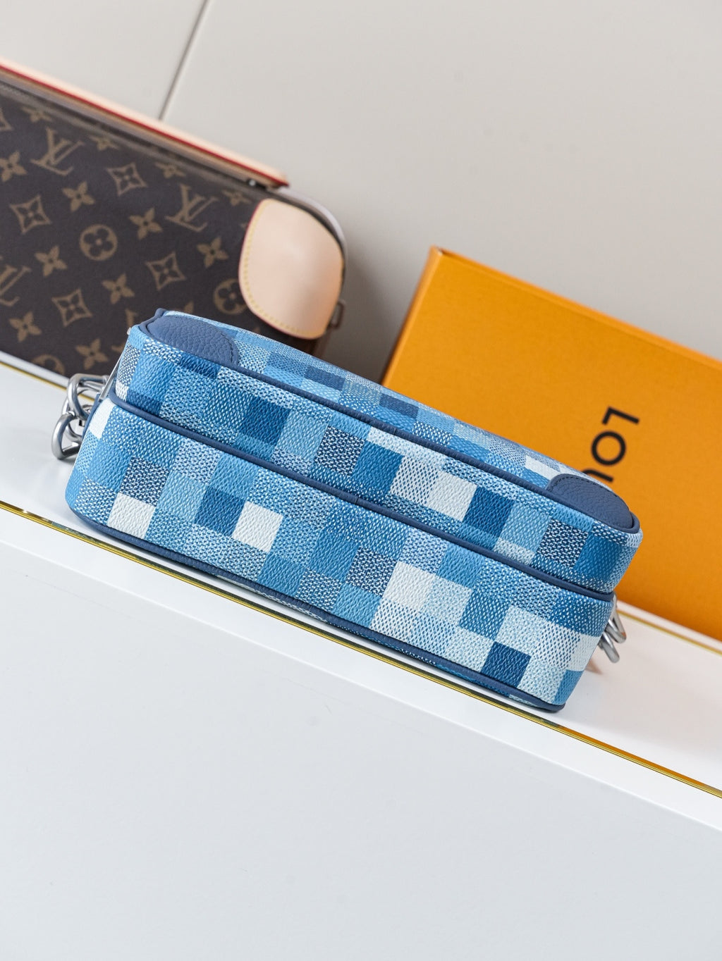 Blue check-pattern crossbody bag with dual zippers and blue strap