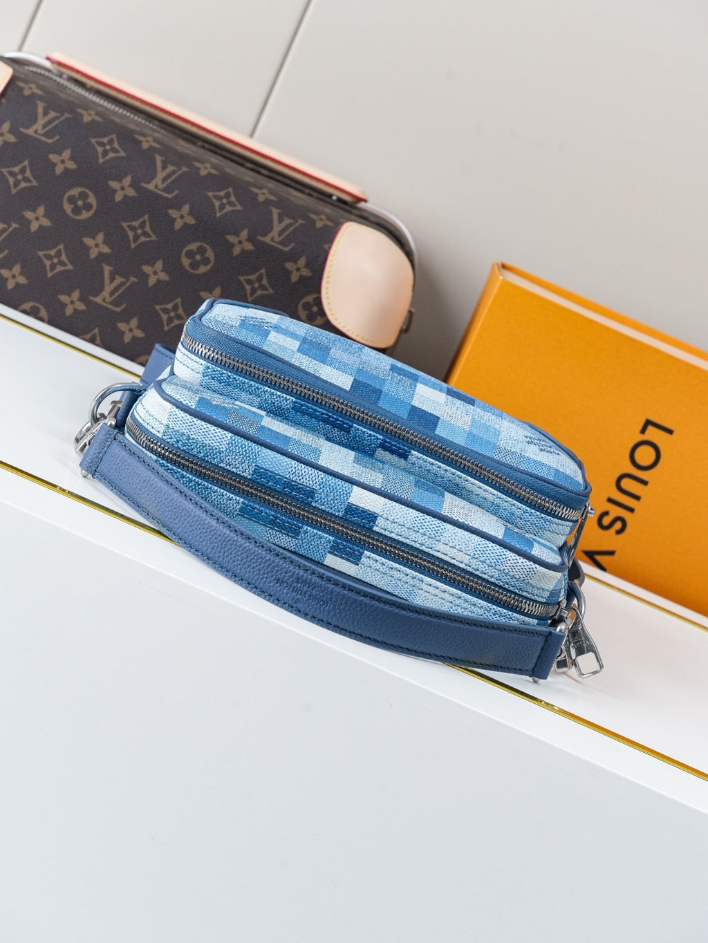 Blue check-pattern crossbody bag with zip closure and blue shoulder strap