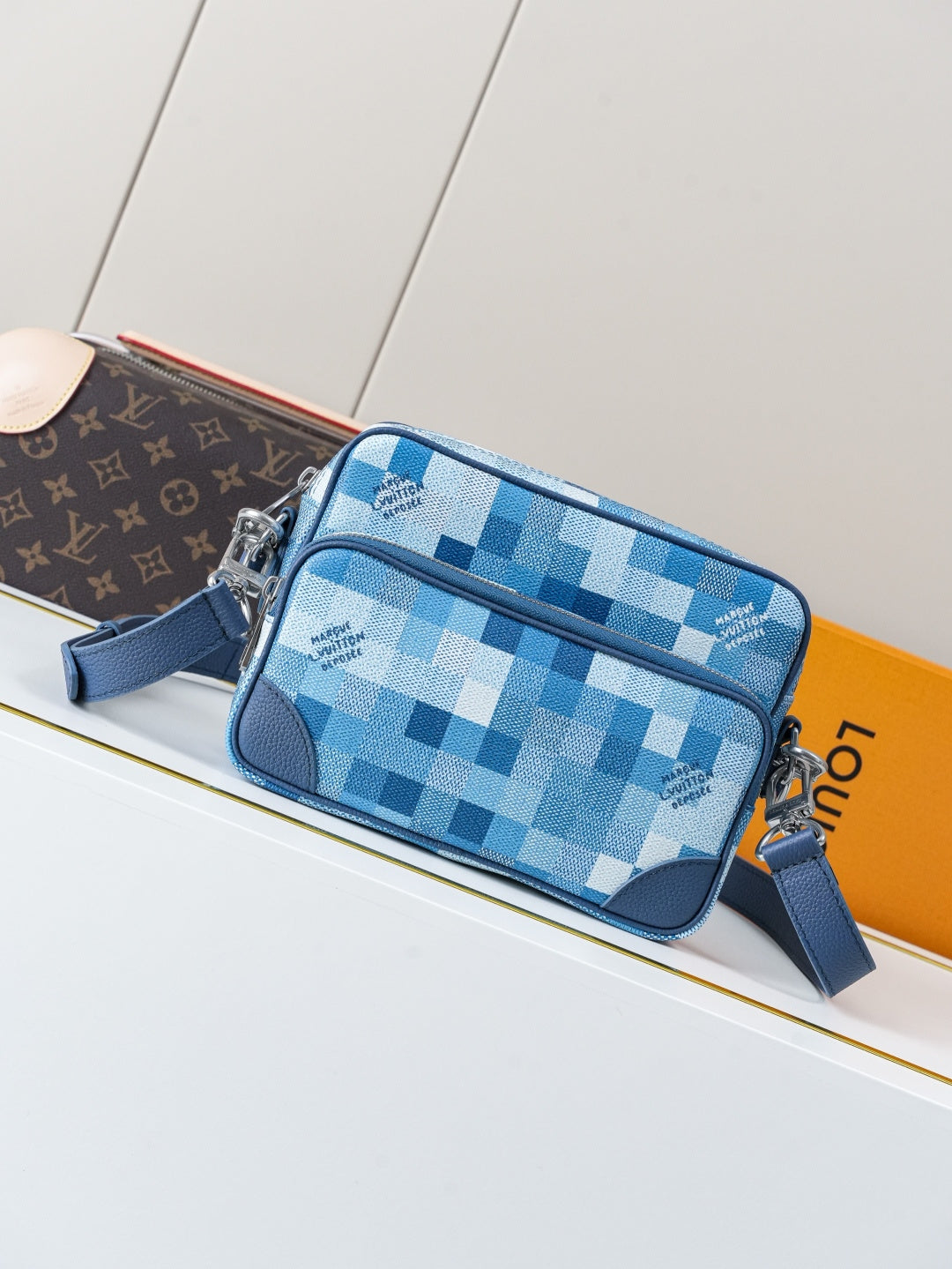 Blue check-pattern crossbody bag with top zip closures and blue strap