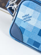 Blue check-pattern bag corner detail with smooth leather trim and stitching