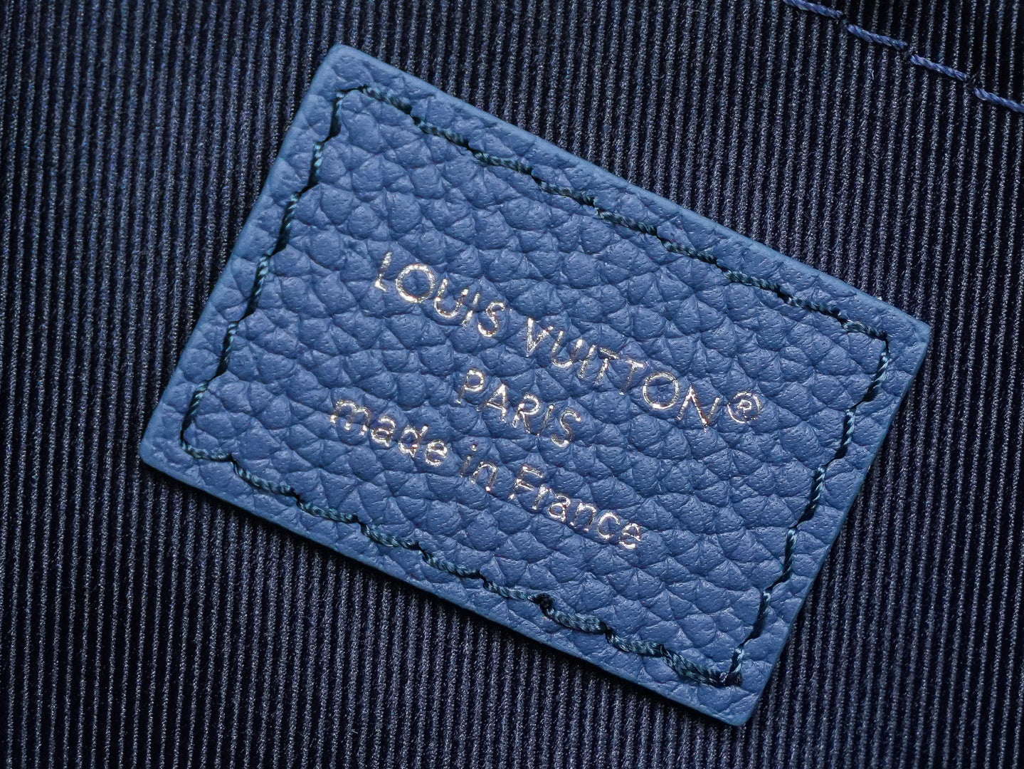 Blue leather interior label reading “Louis Vuitton Paris” with “made in” line