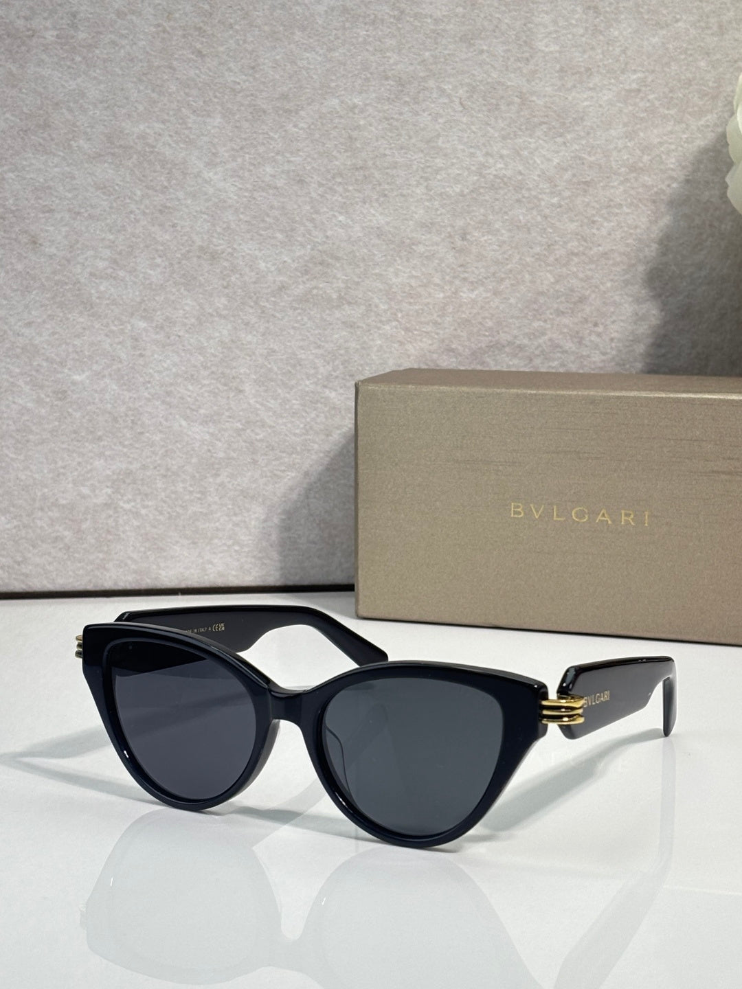 Bvlgari black sunglasses with dark lenses and gold logo on temple arms