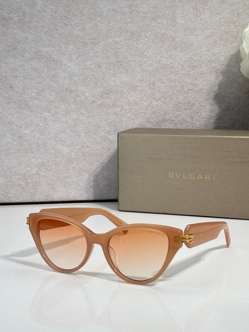 Bvlgari tan cat-eye sunglasses with amber lenses and gold logo on temples