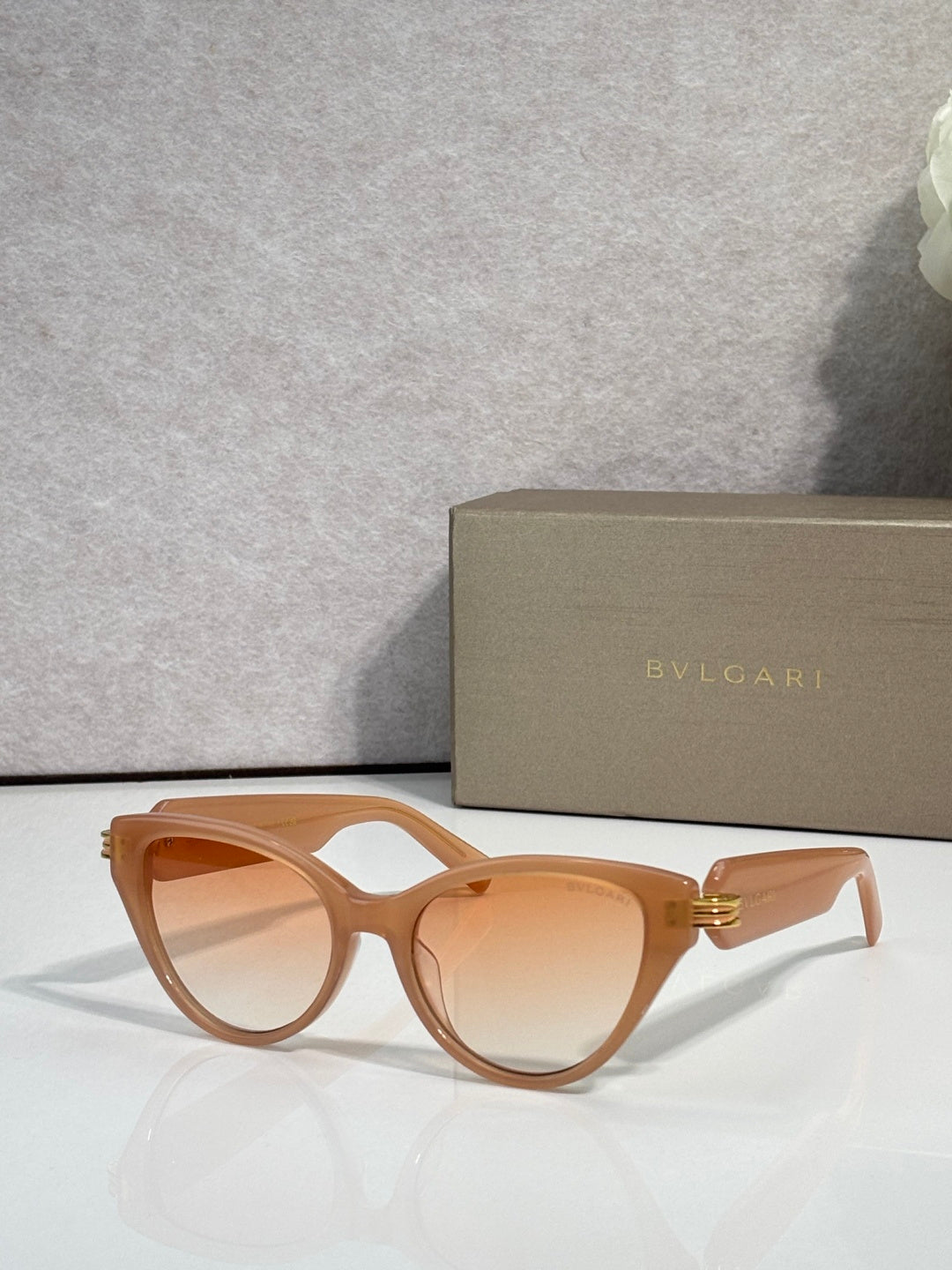 Bvlgari tan cat-eye sunglasses with amber lenses and gold logo on temples