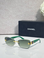 Sunglasses with green frames, gold logo accents, and muted green tinted lenses