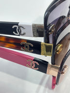 Close-up of stacked sunglasses temples with CHANEL-style logo and engraved gold hardware