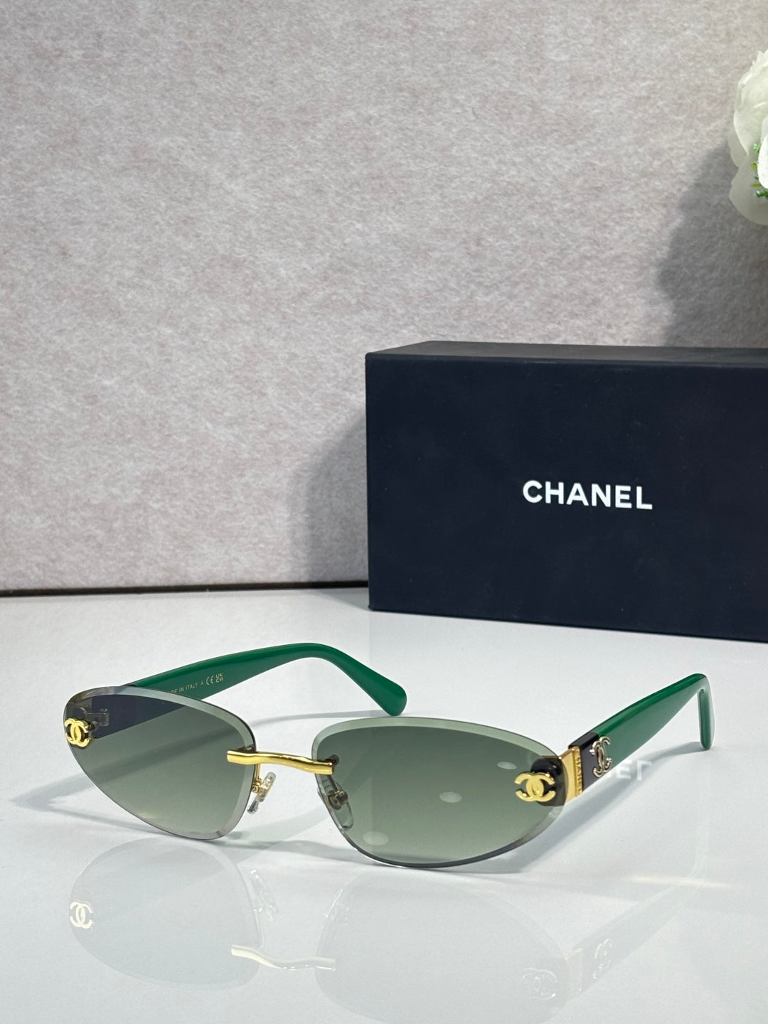 Chanel sunglasses with gold-tone frame and green tinted lenses, green temples