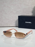 Chanel sunglasses with gold-tone frame and brown tinted lenses, light pink temples