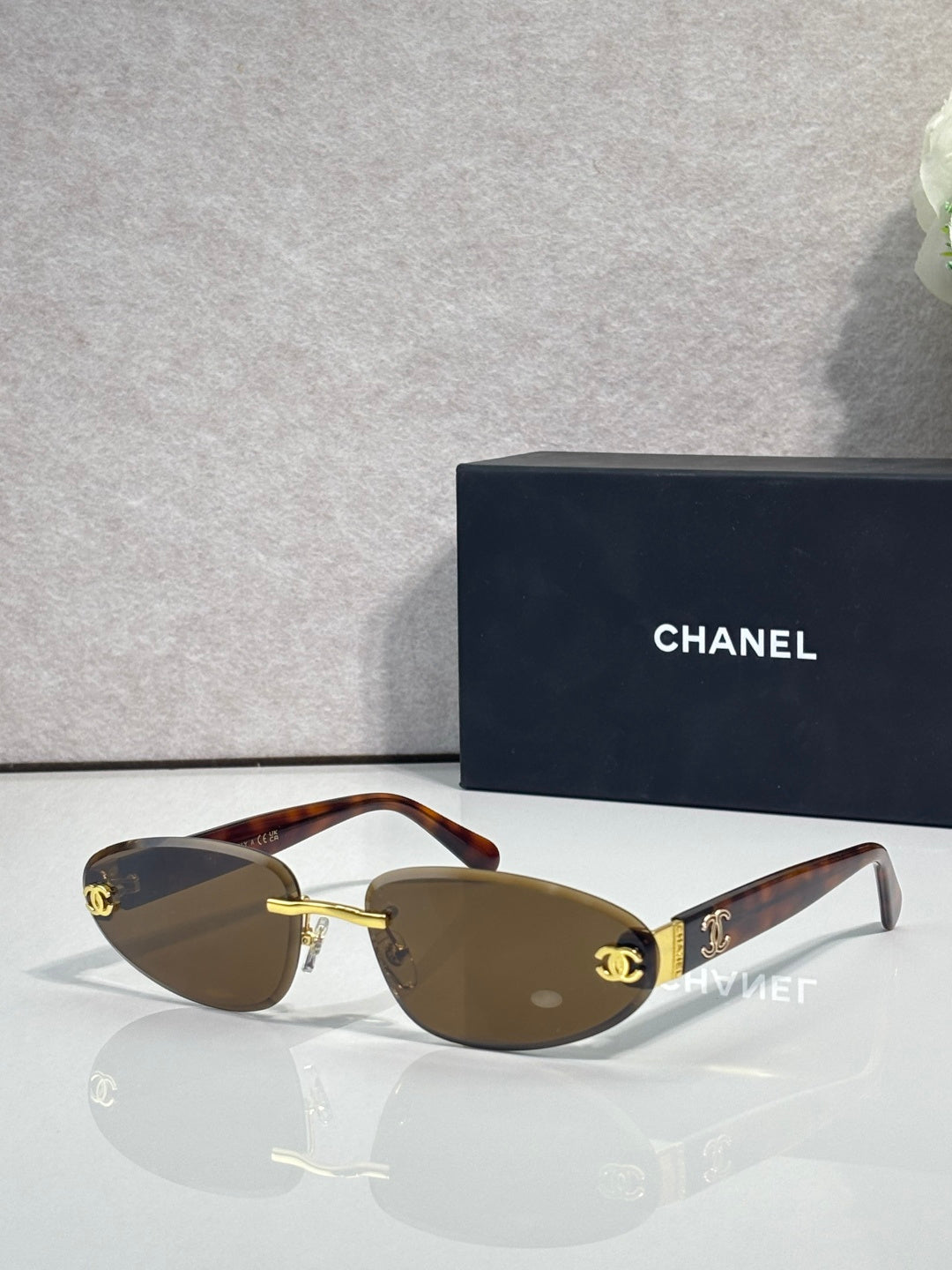 Chanel sunglasses with gold-tone frame and brown tinted lenses, tortoise-style temples