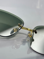 Chanel sunglasses close-up of gold hinge and green-tinted lens edge