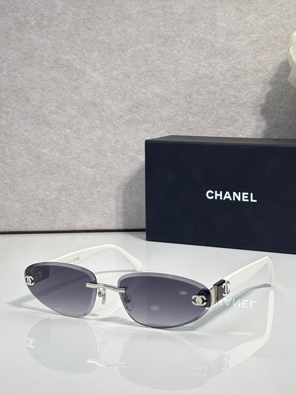 Chanel sunglasses with gold-tone frame and dark tinted lenses, white temples