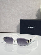 Chanel sunglasses with gold-tone frame and dark tinted lenses, white temples