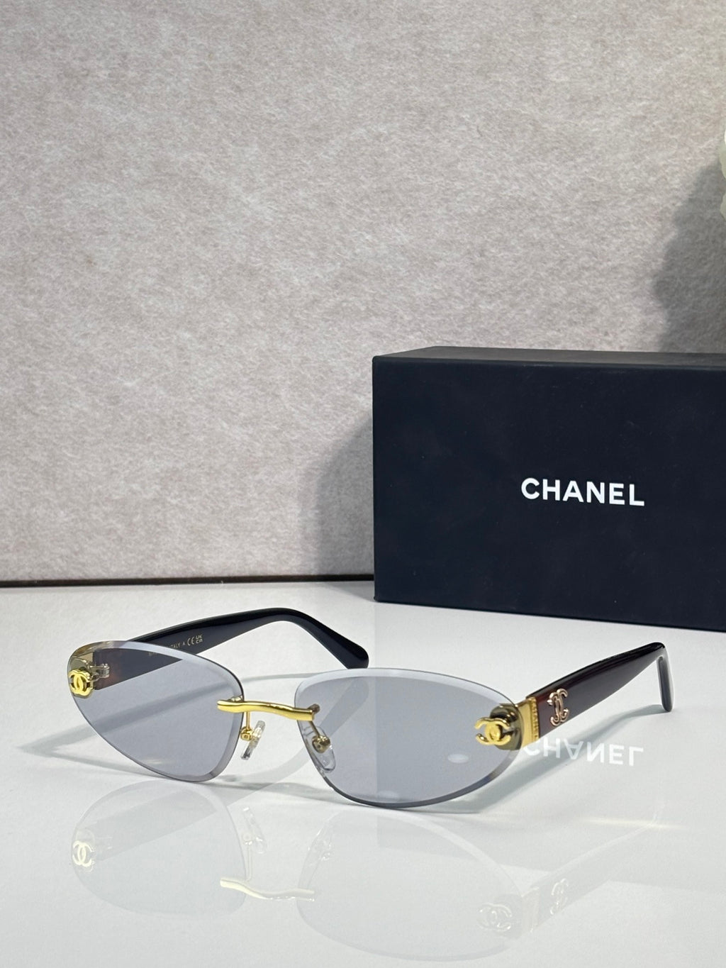Chanel sunglasses with gold-tone frame and clear-to-brown gradient lenses, tortoise temples