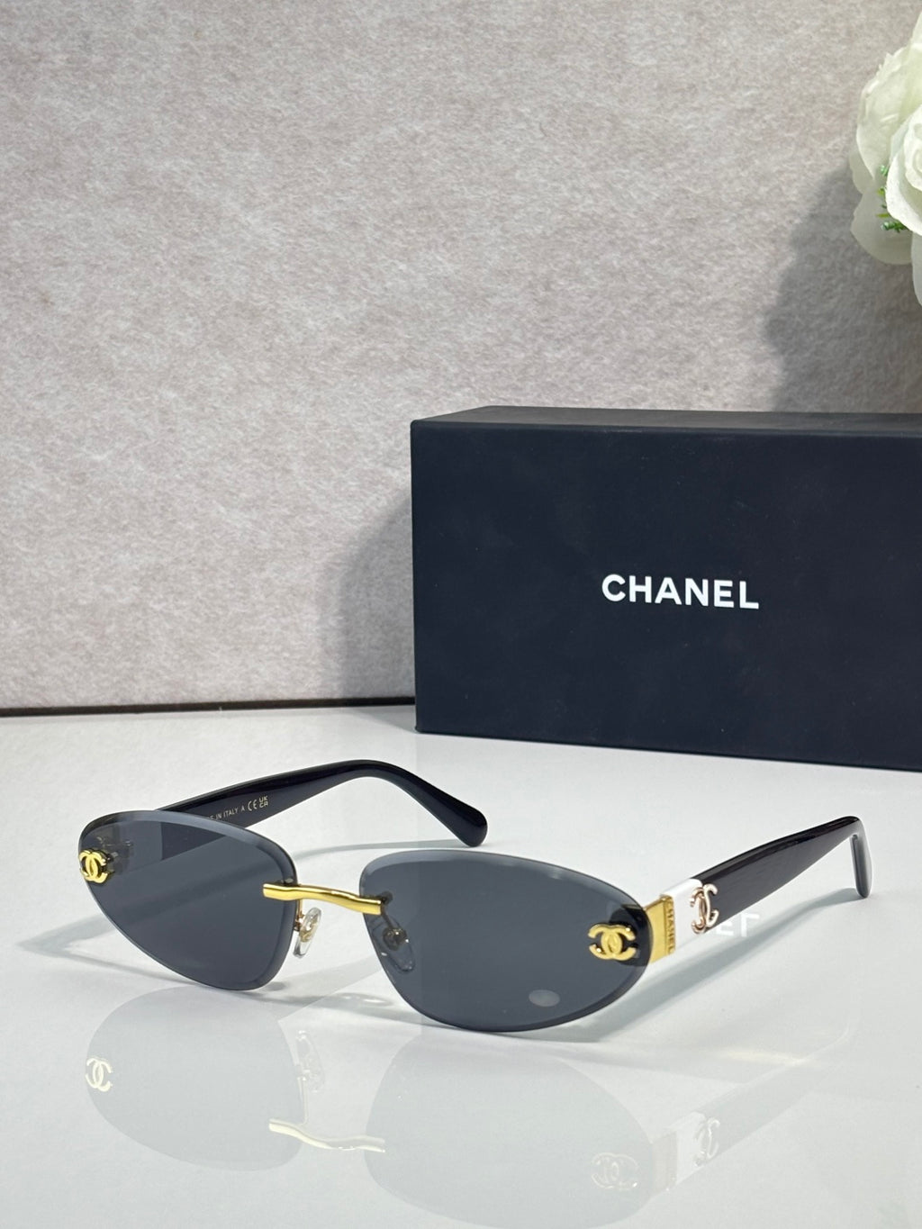Chanel sunglasses with gold-tone frame and blue-gray tinted lenses, dark blue temples