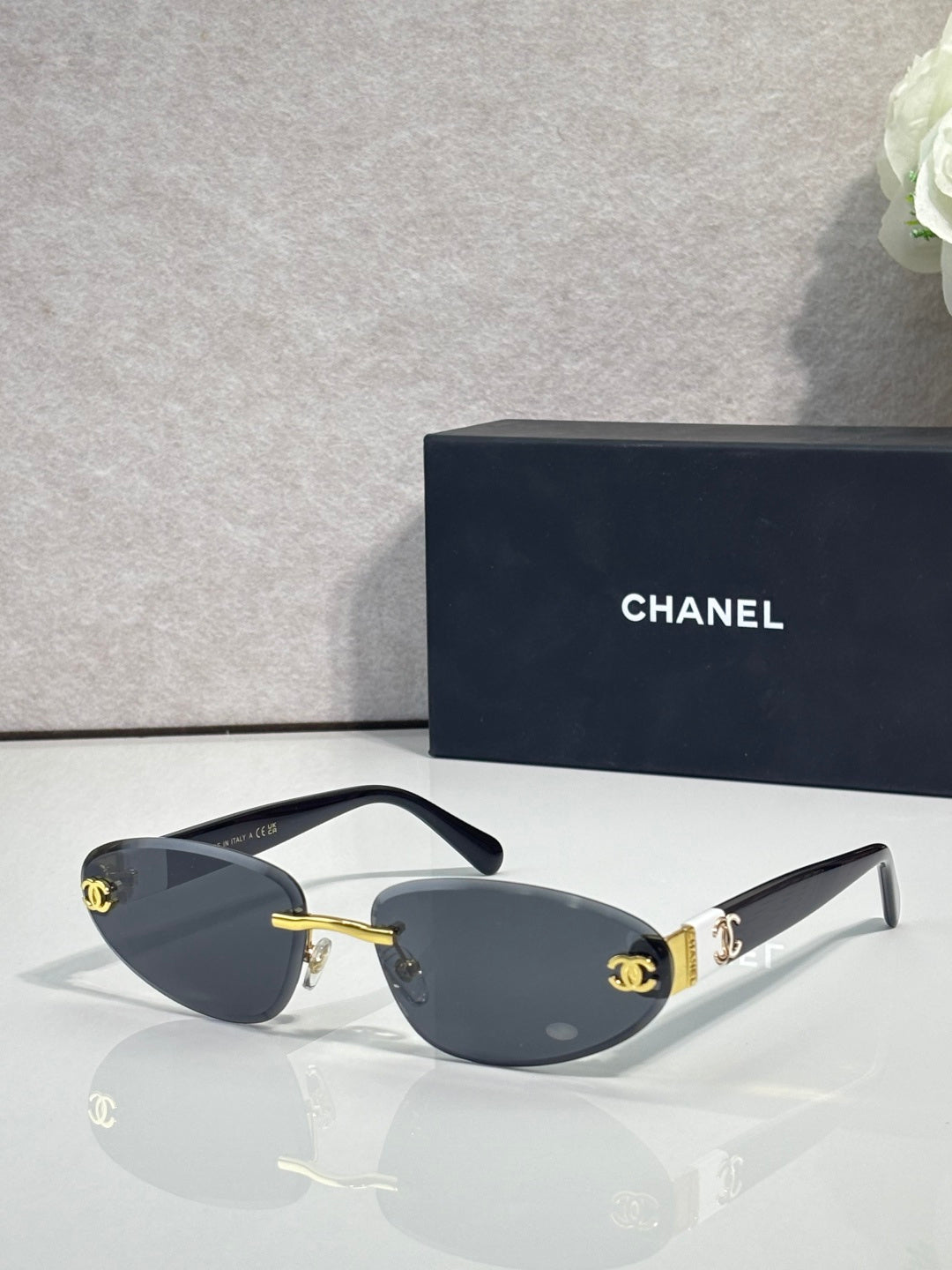 Chanel sunglasses with gold-tone frame and blue-gray tinted lenses, dark blue temples