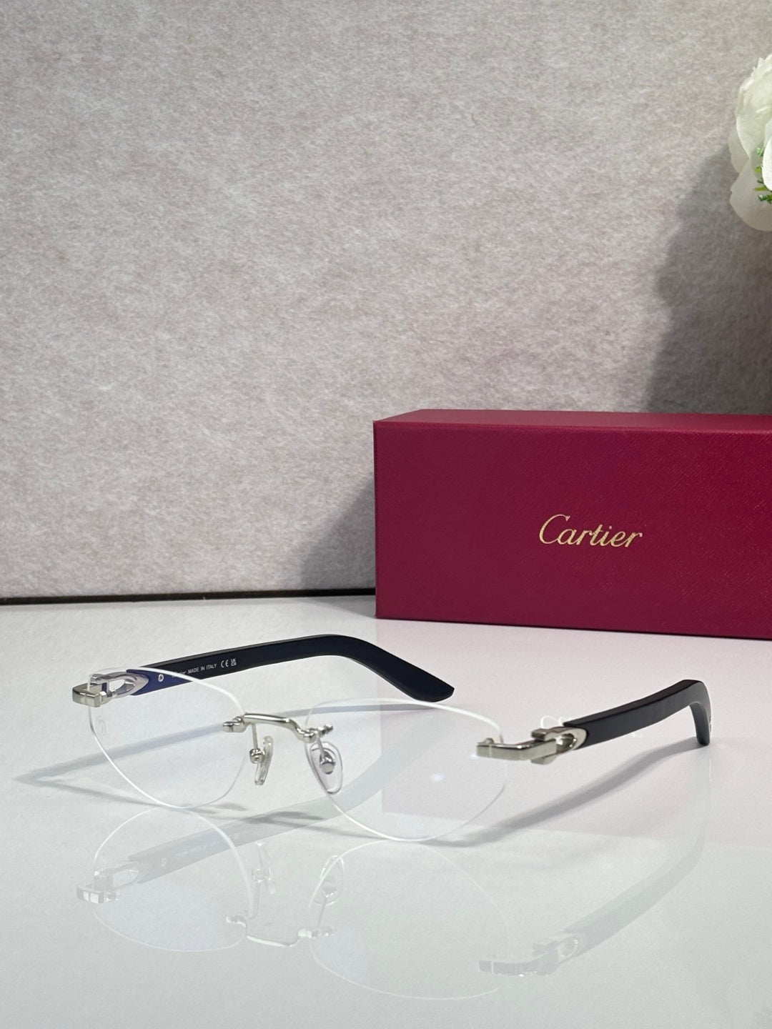 Eyeglass frame with clear lenses, silver-tone metal and dark blue temple details