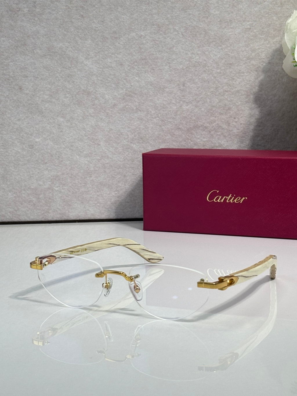 Eyeglass frame with clear lenses, gold-tone metal and patterned light-colored temples