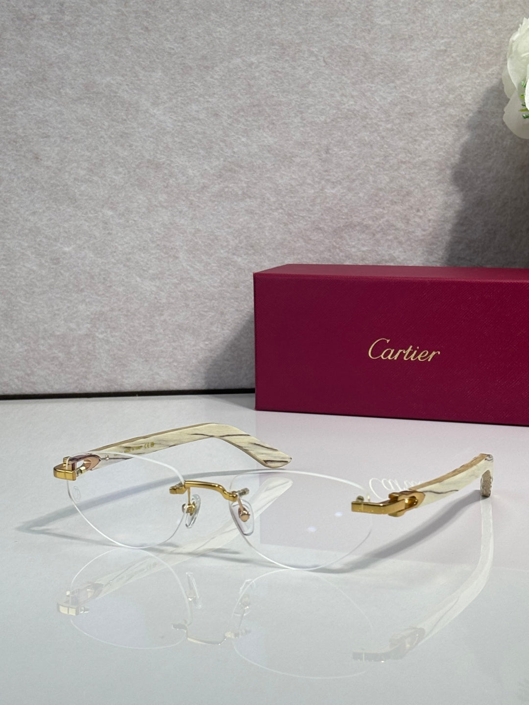 Eyeglass frame with clear lenses, gold-tone metal and patterned light-colored temples