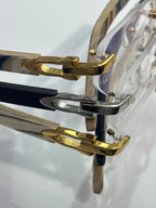 Eyeglass frame detail: gold and silver-tone temple arms with patterned wood-look panels