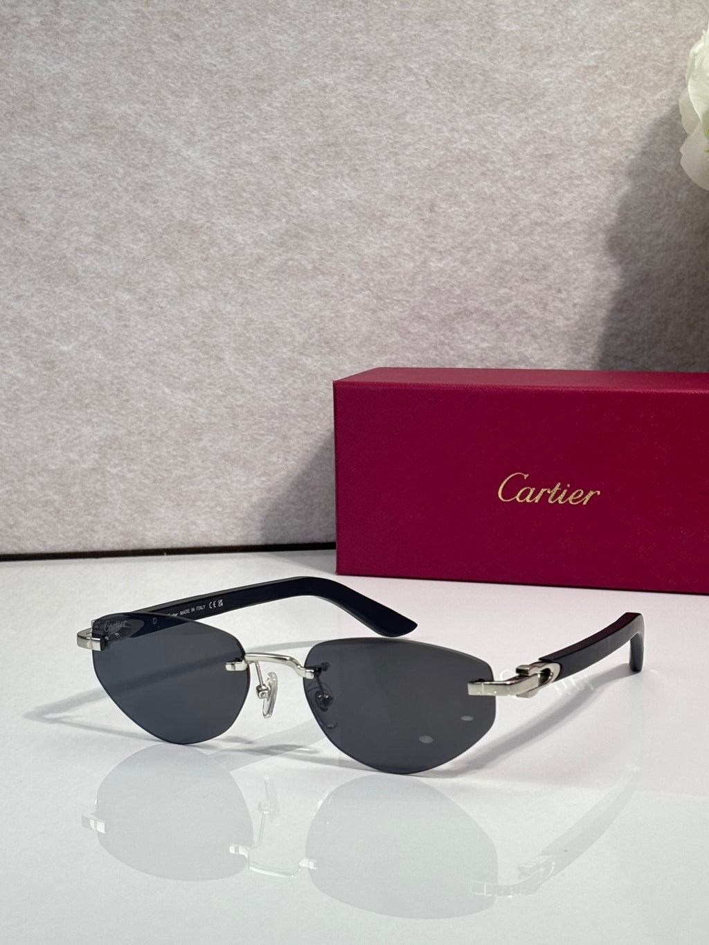 Cartier sunglasses with dark lenses and silver frame, black temple arms and gold hinges