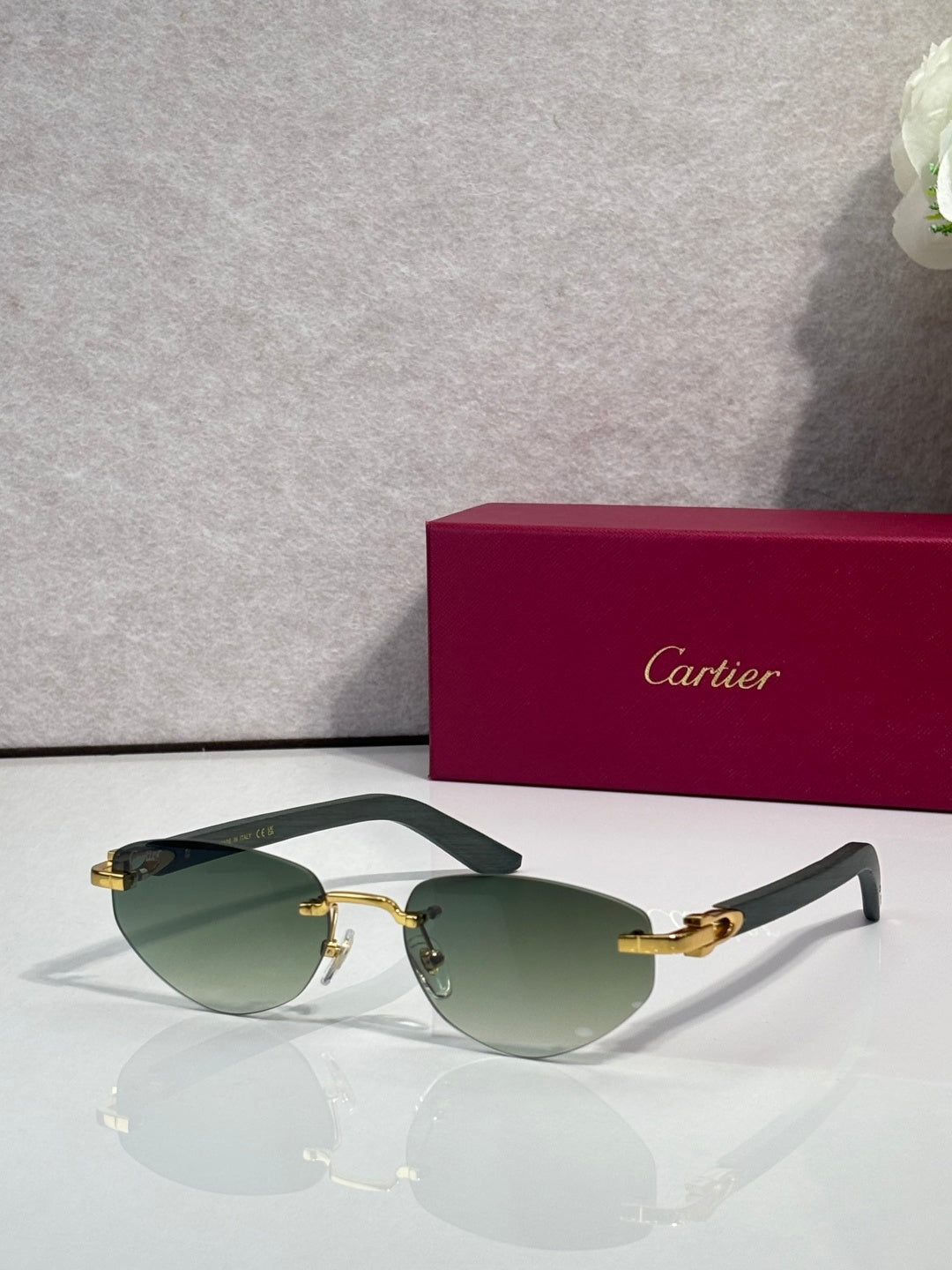 Cartier sunglasses with green tinted lenses and gold-tone frame with metal hinge details