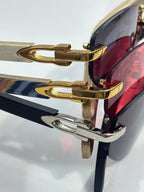 Cartier sunglasses close-up: gold-tone frames with red and dark blue lens tints