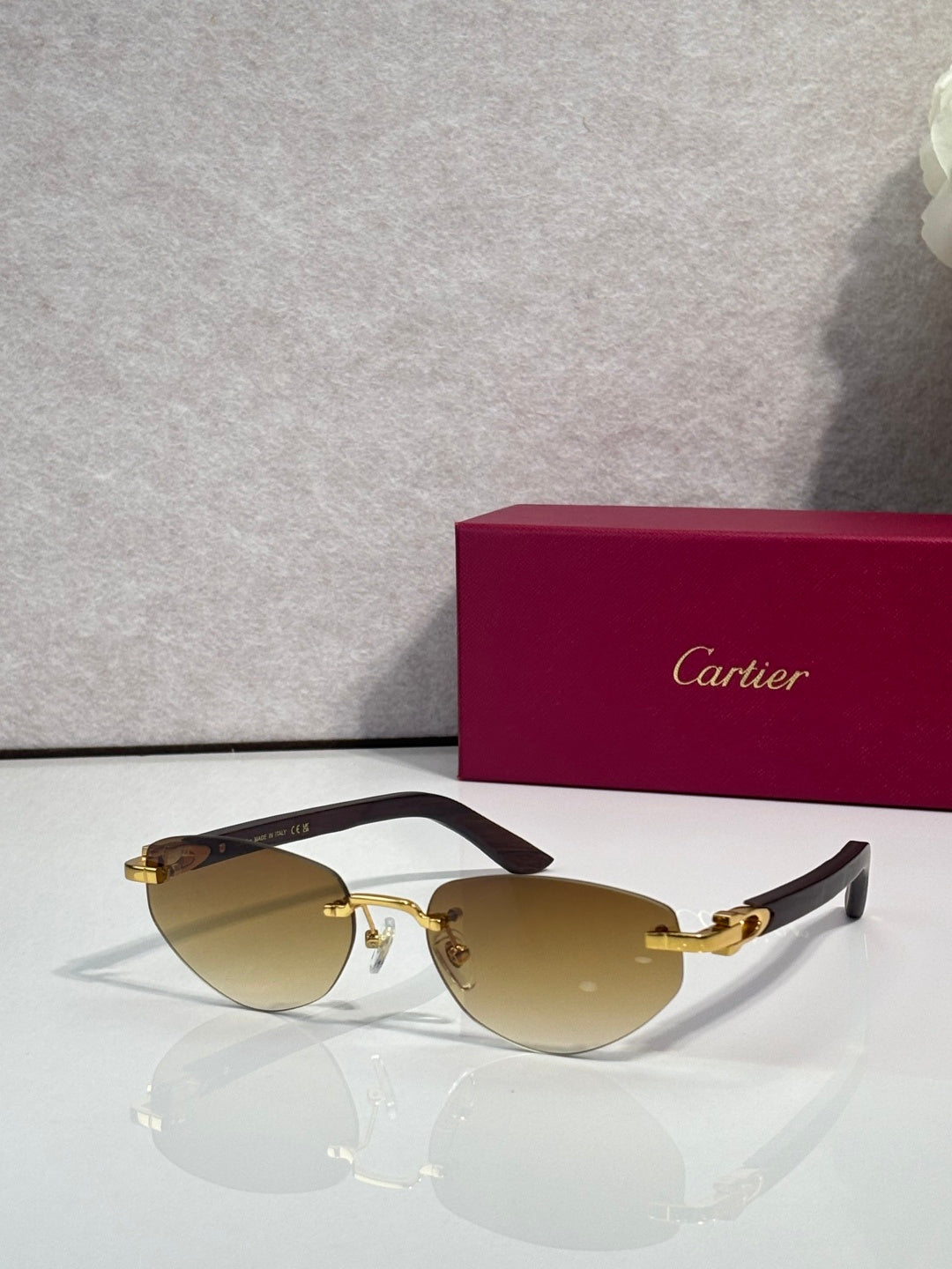 Cartier sunglasses with amber tinted lenses and gold-tone frame, dark temple tips