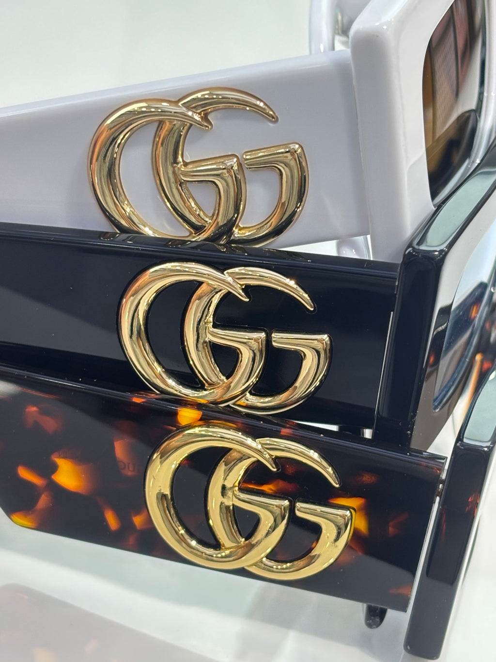 Rectangular sunglasses with gold GG logo on black and white temples