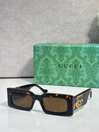 Rectangular dark tortoiseshell sunglasses with amber lenses and gold GG logo