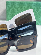 Rectangular sunglasses with layered frames, brown and blue lenses, and GG logo