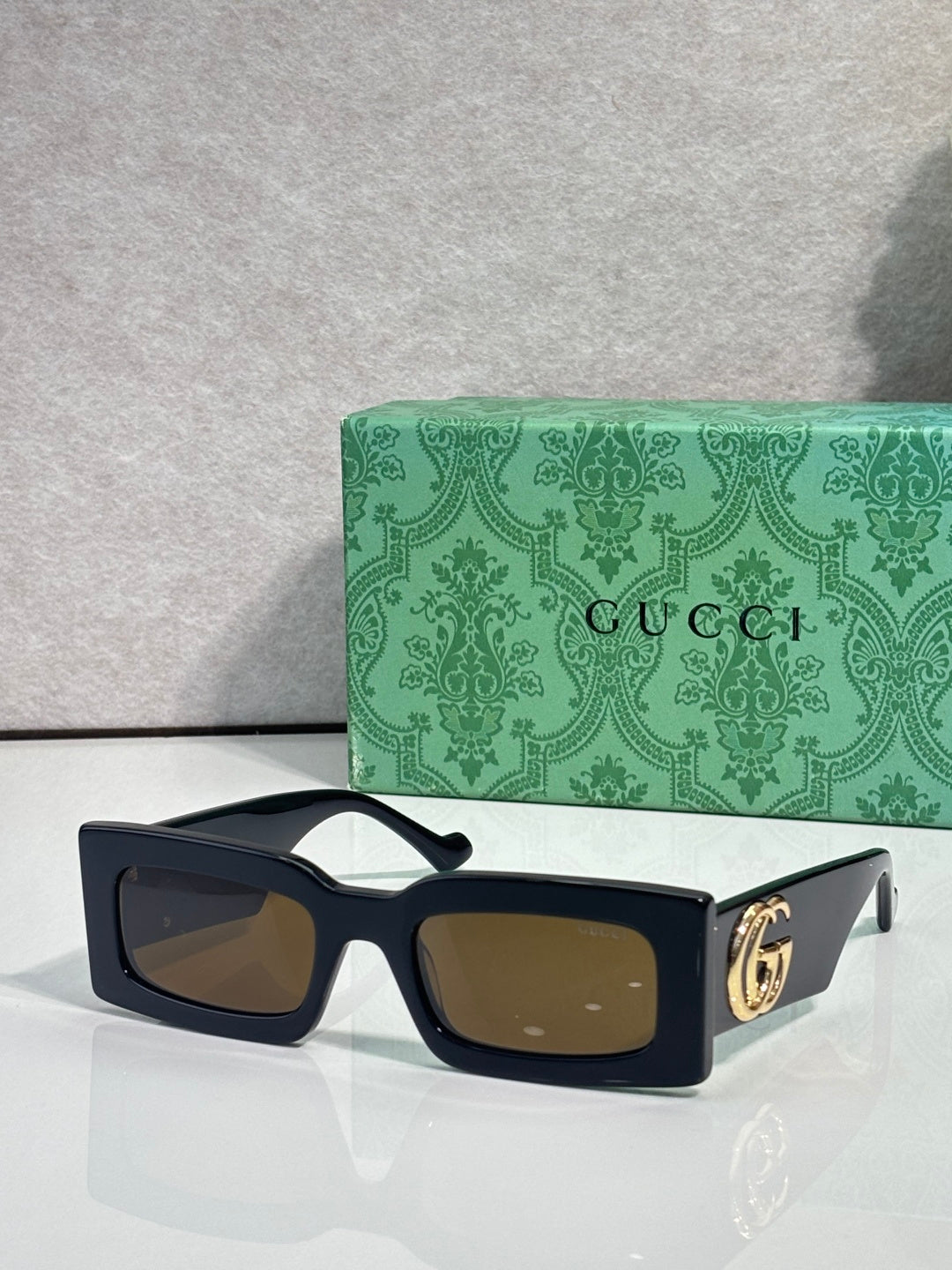 Rectangular black sunglasses with brown lenses and black temples