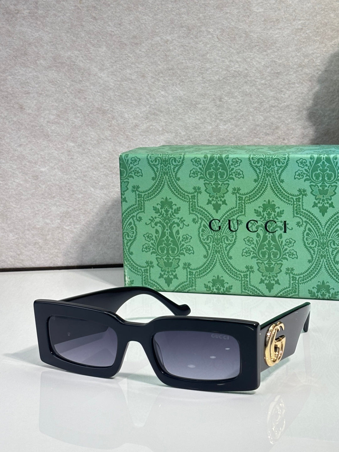 Rectangular black sunglasses with blue-tinted lenses and black temples