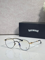 Round eyeglasses with dark blue frame and gold-tone ornate temples