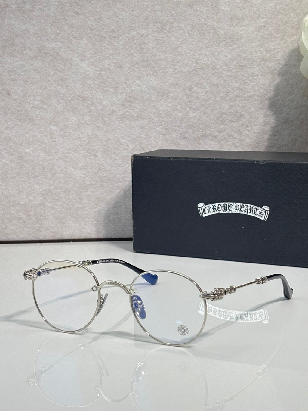 Round eyeglasses with silver-toned frame and blue-tinted temple detail