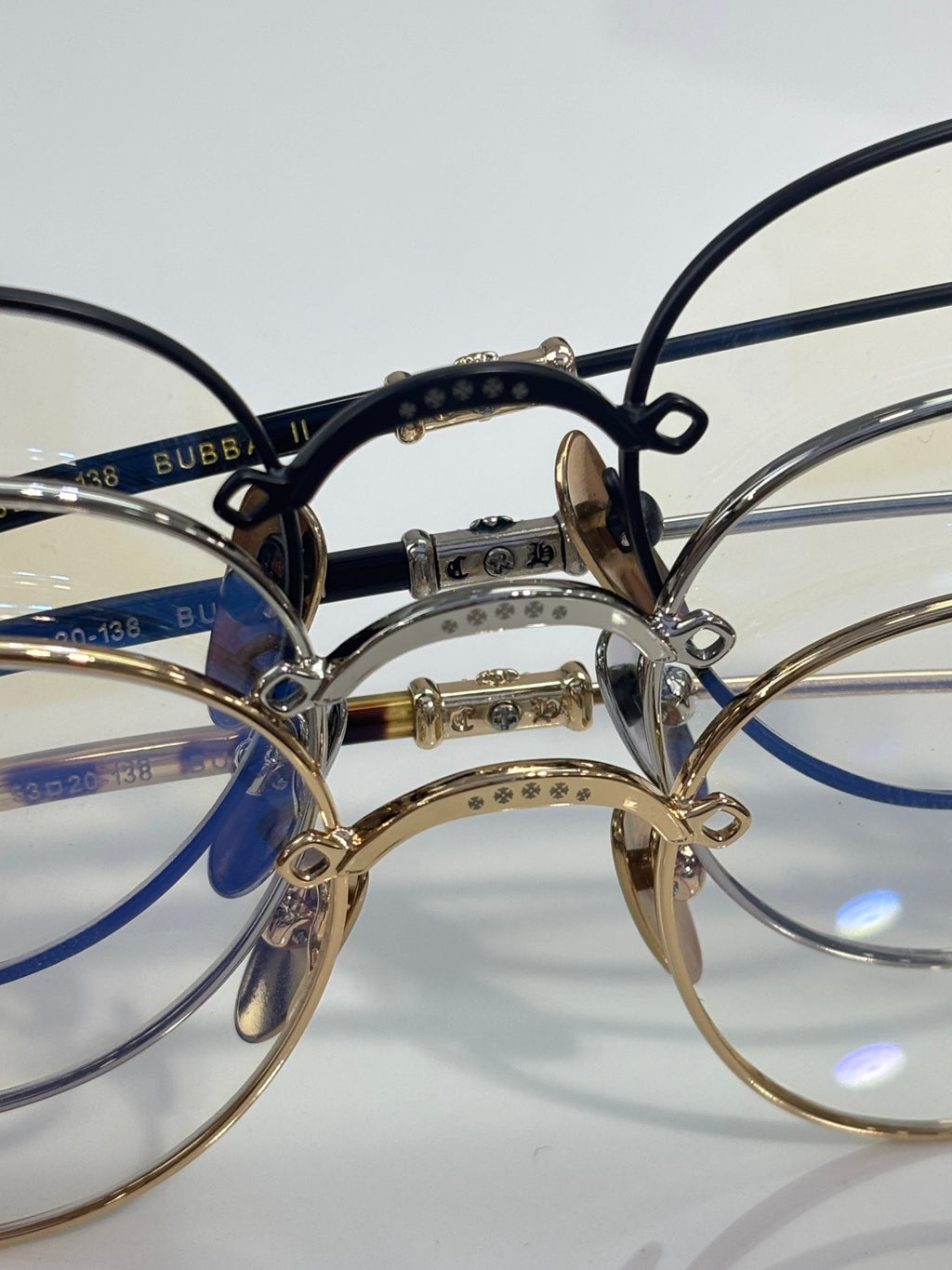 Round eyeglasses close-up with dark blue inner rim and gold-tone bridge