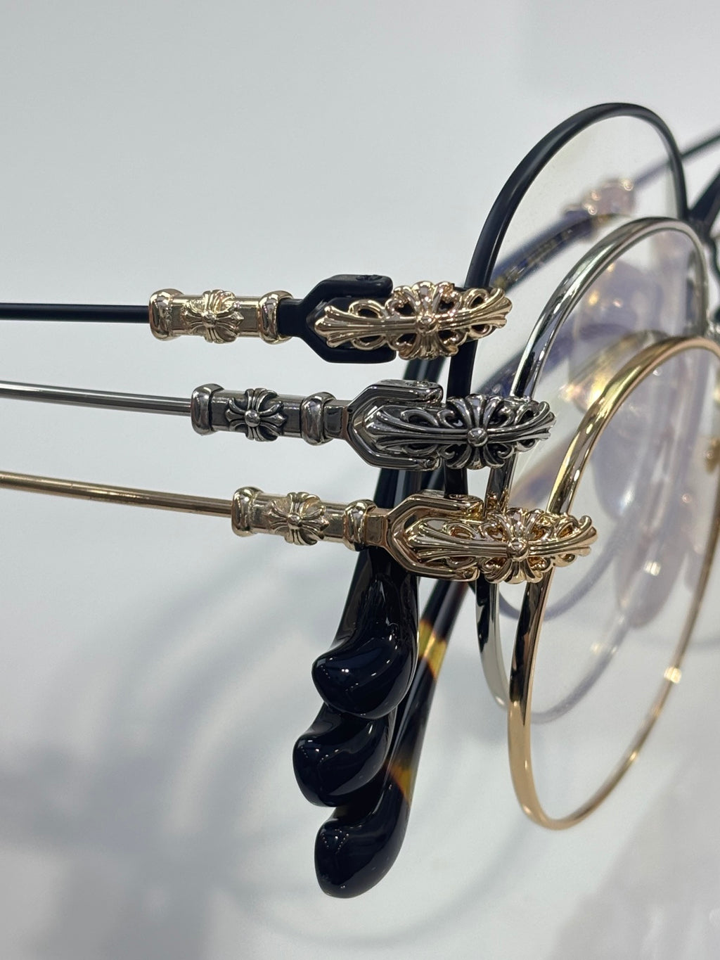 Round eyeglasses with dark blue temples and gold-tone ornate temple accents