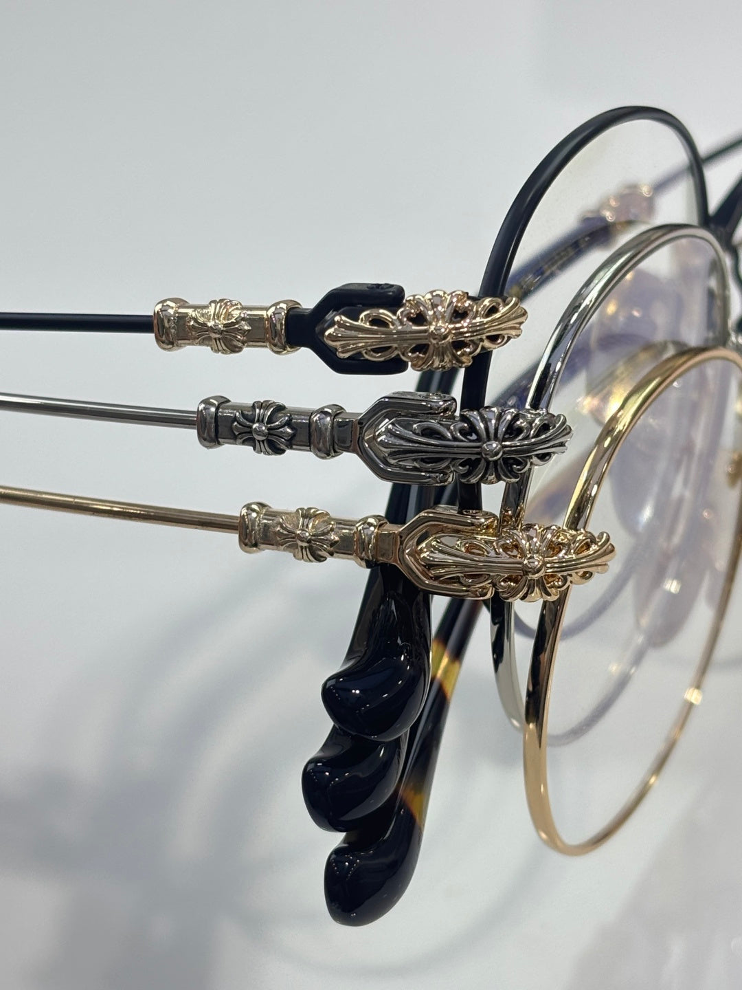 Round eyeglasses with dark blue temples and gold-tone ornate temple accents