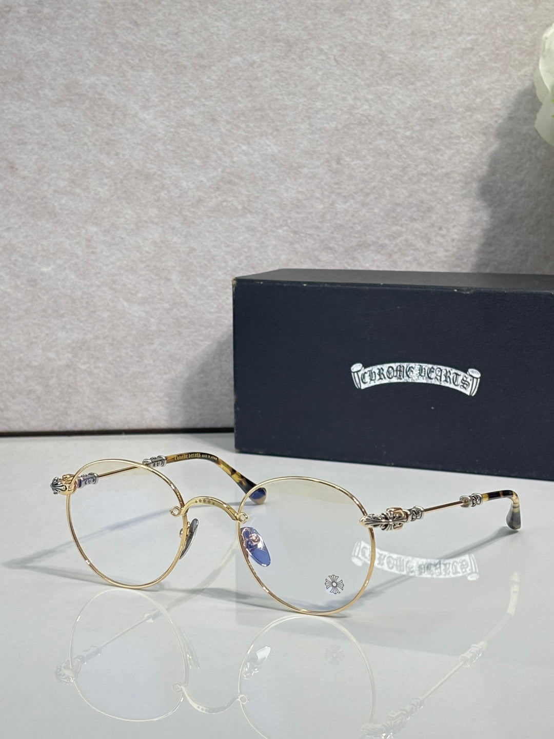 Round eyeglasses with gold-tone frame and ornate gold temple accents