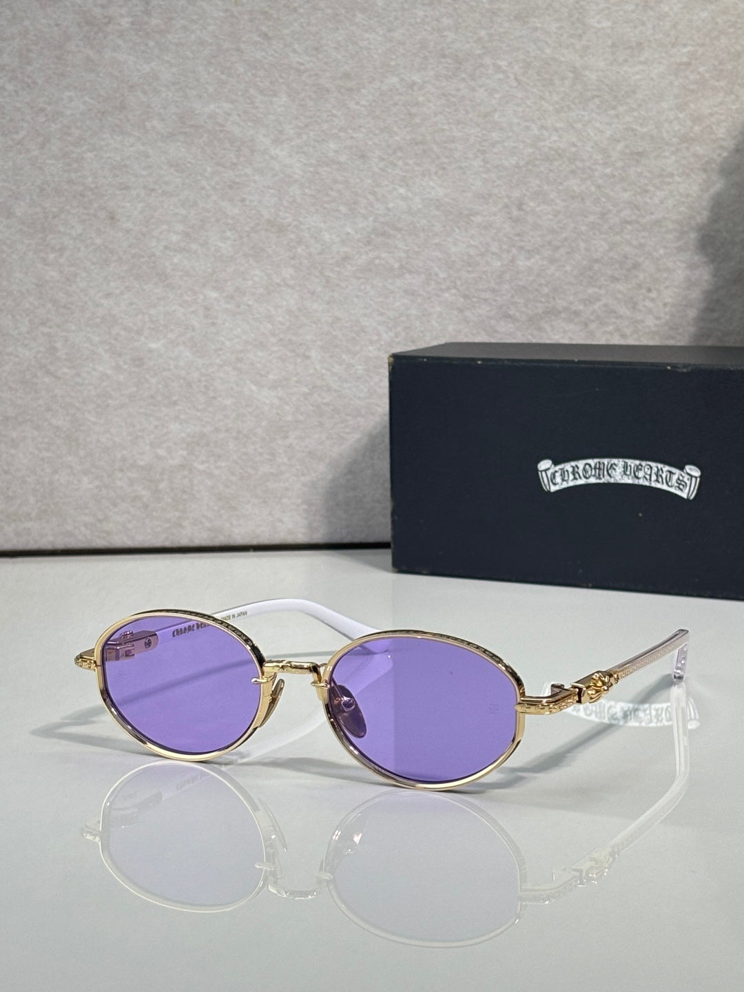 Chrome glasses with round purple lenses and gold-and-silver frames, clear temples.