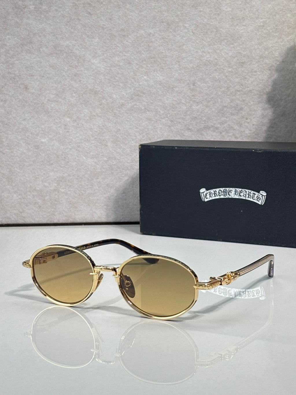 Chrome glasses with round amber lenses and gold frames, clear temples.