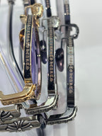 Chrome glasses detail: round frames with engraved temple text and gold accents.