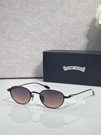 Round sunglasses with dark lenses, black frame, and chrome temple details